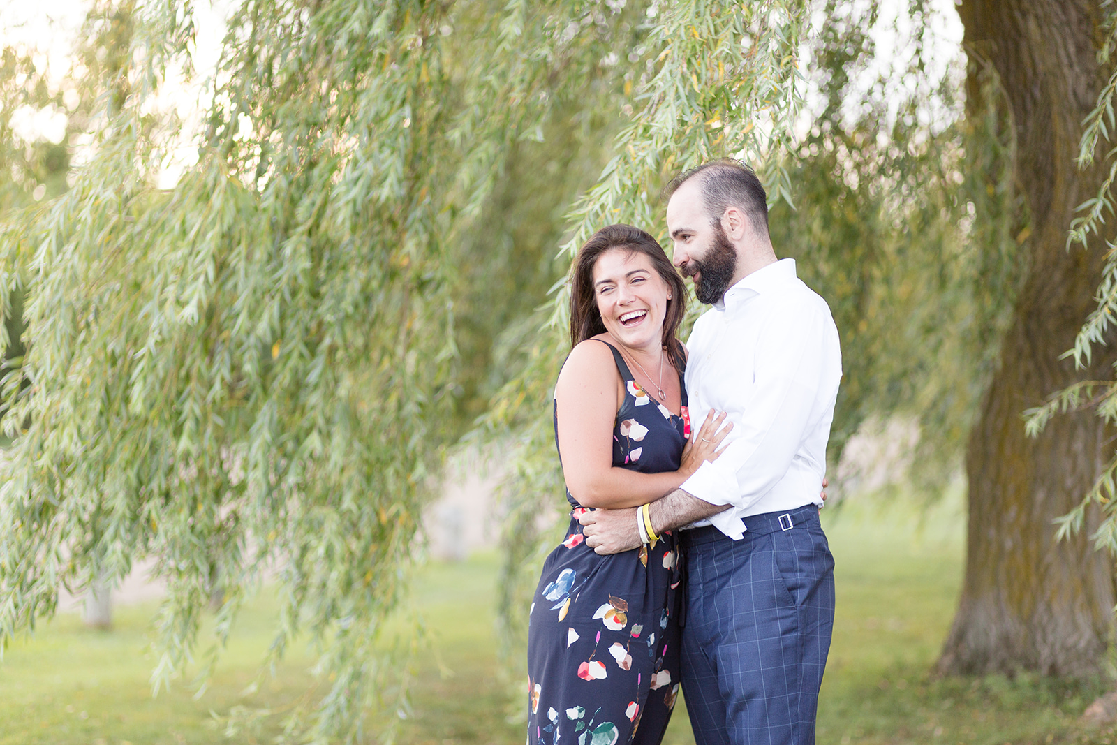couple laughing in front of willow tree guelph engagement photos